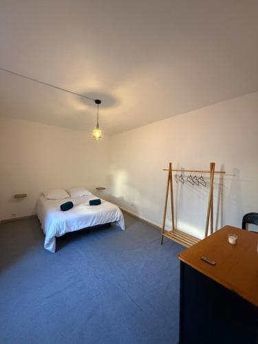 a bedroom with a bed and a desk and a table at Grand T2 en centre-ville quartier historique in Fontenay-le-Comte