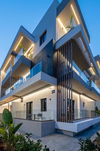 a large white building with balconies at night at Unicos City Suites in Kos Town