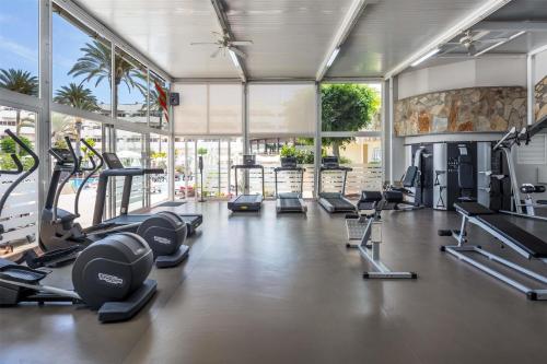 a gym with a lot of treadmills and machines at Barceló Corralejo Bay - Adults Only in Corralejo