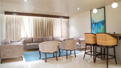 a living room with a couch and a table and chairs at Radisson Blu Resort Visakhapatnam in Visakhapatnam