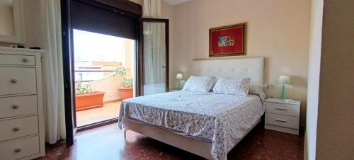 ein Schlafzimmer mit einem Bett und einer Tür zu einem Balkon in der Unterkunft Bustamante in Roquetas de Mar