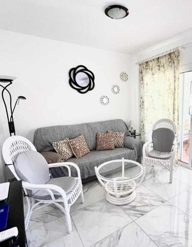 a living room with a gray couch and chairs at SHR043 Nerja Medina Apartamento cerca de Playa Torrecilla in Nerja