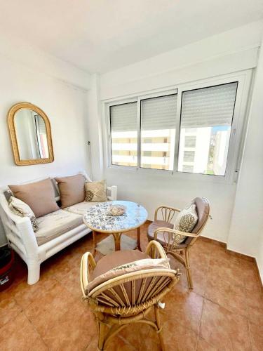 a living room with a couch and a table and chairs at SHR043 Nerja Medina Apartamento cerca de Playa Torrecilla in Nerja