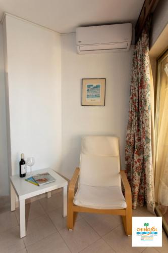 a chair and a table in a room at Apartamentos Chinasol in Almuñécar