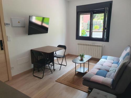 a living room with a couch and a table at Sella Rooms in Arriondas