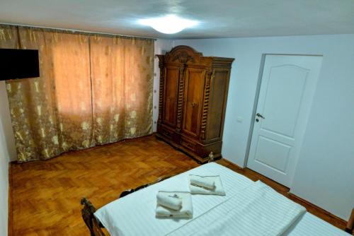 a room with a white table and a wooden cabinet at Agropensiune Lupu 