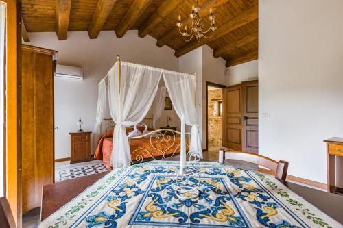 a bedroom with a bed with a blue and white comforter at Arcaloro Resort Rooms in SantʼAngelo di Brolo