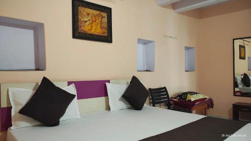 a bedroom with a bed with black and white pillows at Radha Krishna Home in Varanasi