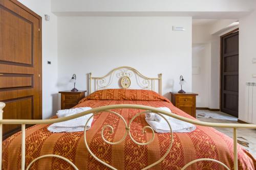 a bedroom with a bed with a red bedspread at Arcaloro Resort Rooms in SantʼAngelo di Brolo