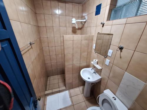 a bathroom with a sink and a toilet and a mirror at Pousada DONA DUTRA in Lençóis Paulista