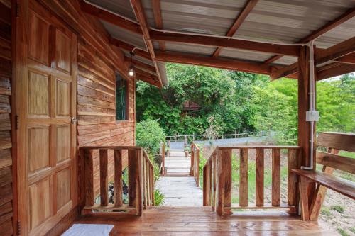 an entrance to a wooden house with a wooden door at บ้านสวนแก้วคำแพง Baan Suan Kaew Khampaeng in Udon Thani
