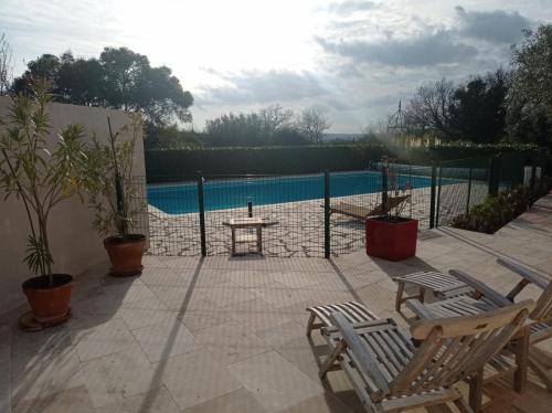 une terrasse avec des chaises, une table et une piscine dans l'établissement Maison provençale Verdon, à Aups