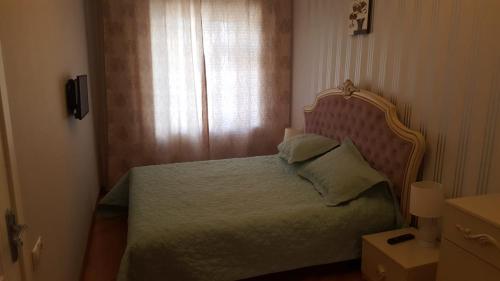una camera da letto con un letto con testiera e una finestra di Квартира a Baku