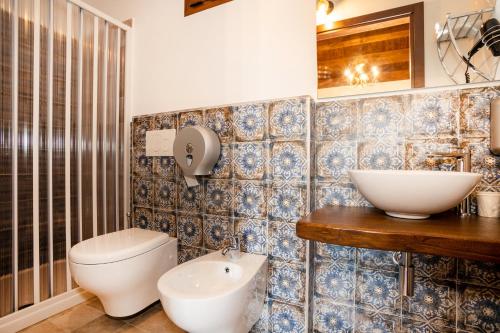 a bathroom with a toilet and a sink at Arcaloro Resort Rooms in SantʼAngelo di Brolo