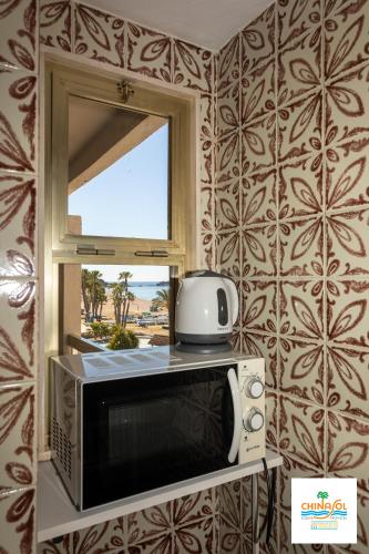 a microwave and a window in a room at Chinasol Suites in Almuñécar
