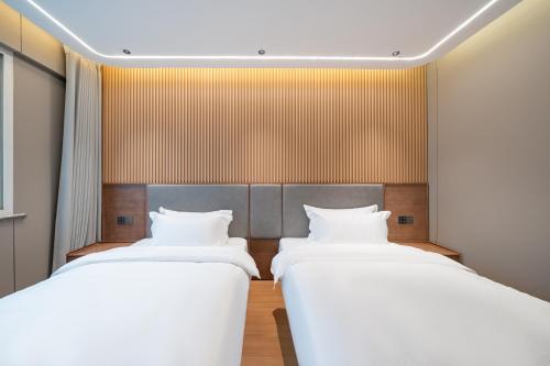 Postel nebo postele na pokoji v ubytování Xihe Hotel - Shanghai Jiuyuan Xietu Road Branch