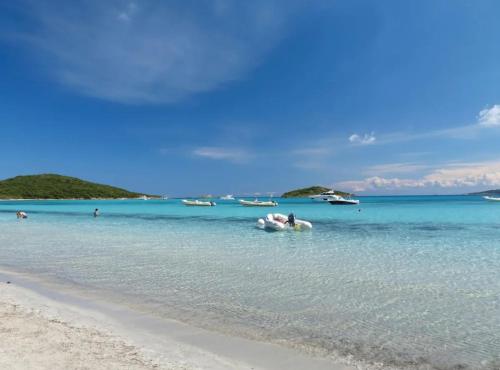 a couple laying in the water at the beach at CASA ANPÀ Maison Vue Mer in Lecci