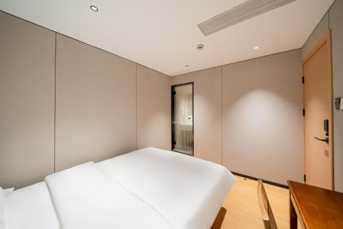 Postel nebo postele na pokoji v ubytování Xihe Hotel - Shanghai Jiuyuan Xietu Road Branch