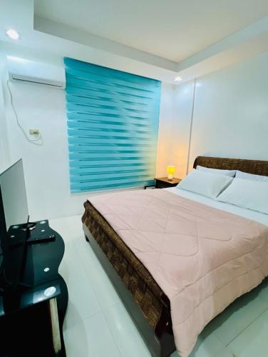 a bedroom with a large bed and a window at Poolside Condo in Subic Bay in Olongapo