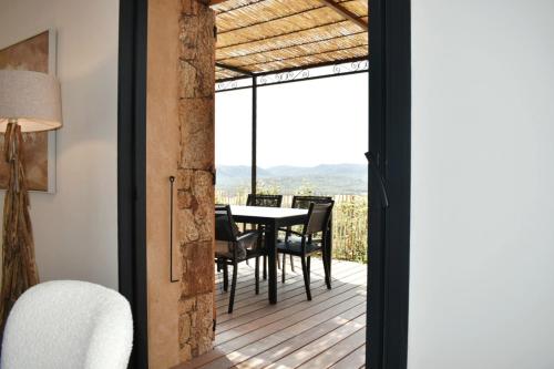 ein Esszimmer mit einer Terrasse mit einem Tisch und Stühlen in der Unterkunft Amandula Bergerie Sotta hyper cozy in Sotta