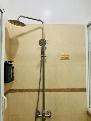 a shower head in a bathroom with a wall at Poolside Condo in Subic Bay in Olongapo