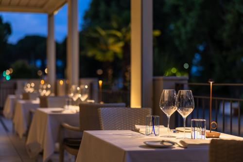 a row of tables with wine glasses on a patio at Villa Rosa Hotel Desenzano in Desenzano del Garda