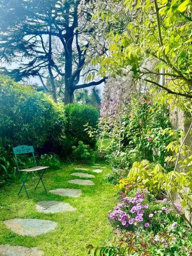a garden with a bench and some flowers at Les jardins du Tôt in Fermanville