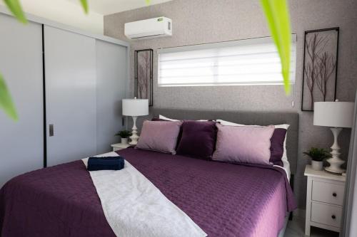 a bedroom with a purple bed and a window at Book Villa 1002 Luxury in Sosua in Sosúa