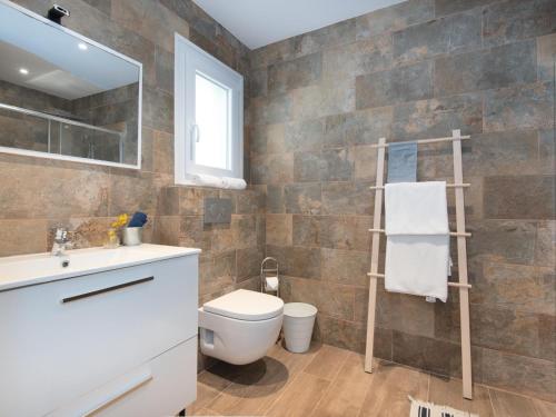 a bathroom with a toilet and a sink and a mirror at Domus A B 6 Pax in Portocolom