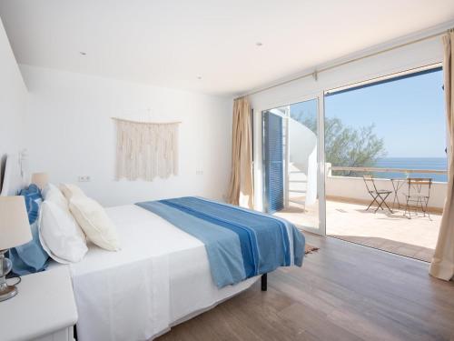 a bedroom with a bed with a view of the ocean at Domus A B 6 Pax in Portocolom