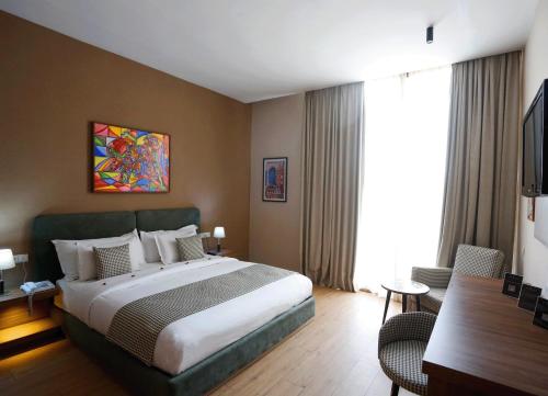 a hotel room with a large bed and a desk at Rawabi Hotel Marrakech & Spa in Marrakech