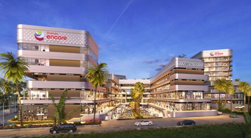 a large building with cars parked in a parking lot at Ramada Encore by Wyndham Gurugram Dwarka Expressway in Gurgaon