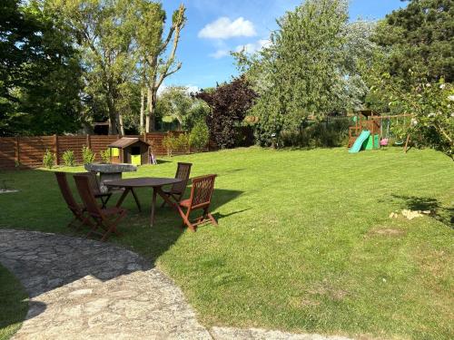 a picnic table and chairs in a yard with a playground at La Source in Breuil