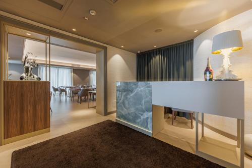 a living room with a fireplace and a dining room at Villa Rosa Hotel Desenzano in Desenzano del Garda