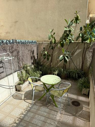 un patio avec une table, des chaises et des plantes dans l'établissement Charmant studio avec terrasse, à Nice