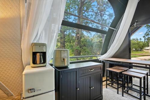a kitchen with a window and a table with chairs at Cloud Nine Tent #2 - The Spruce Suite in Hermosa