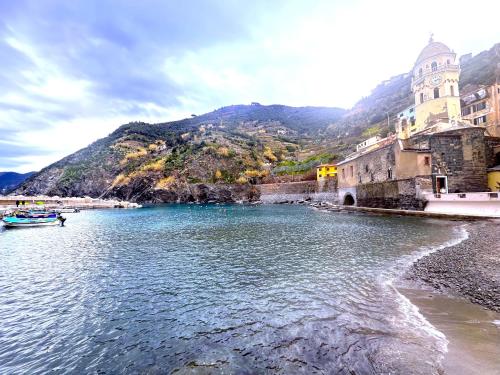 a body of water with a mountain in the background at The Vernazza Spot in Vernazza