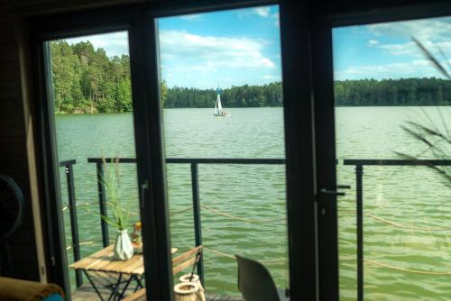 a view of a sailboat in the water from a window at Ruciane Park - Mazury resort & spa in Ruciane-Nida