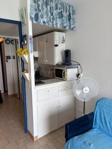 une petite cuisine avec une table et un micro-ondes dans l'établissement Studio Kamarina, à Sanary-sur-Mer