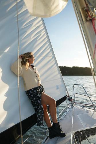 a woman sitting on the sail of a boat at Ruciane Park - Mazury resort & spa in Ruciane-Nida