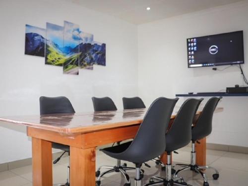 una sala de conferencias con una mesa y sillas de madera en Dukes Chambers, en Harrismith