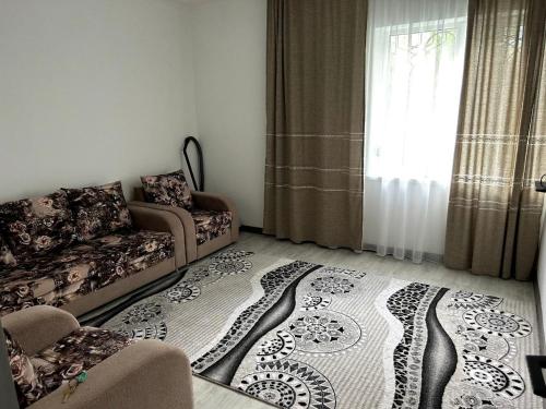 a living room with a couch and a rug at Lucky's House in Cholpon-Ata