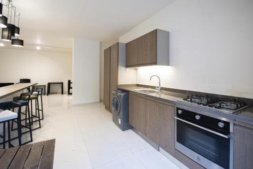 a kitchen with a stove and a sink and a dishwasher at Tabarja Hills apartment in ‘Ayn aş Şughayrah