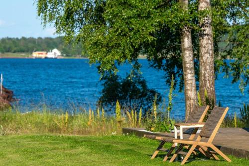 two chairs sitting on a wooden dock near a lake at RS Noatun in Horten