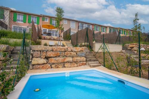 une piscine dans une cour avec un bâtiment dans l'établissement 70m2, piscine , 2 chambres, à La Garde-Freinet