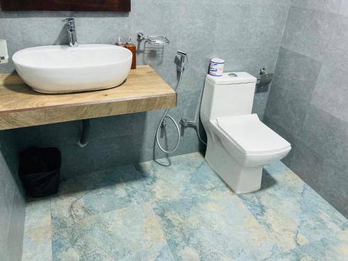 a bathroom with a white toilet and a sink at Ever Breeze Ella Hotel in Ella