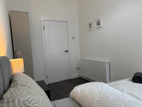 a bedroom with two beds and a white door at ResiLets - NEW 3 Bed Apt, Sleeps 5, Town Centre, Ideal for contractors, holidaymakers, Professional Short Stay in Blythe