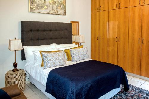 a bedroom with a large bed with a blue blanket at Windhoek self accommodation in Windhoek