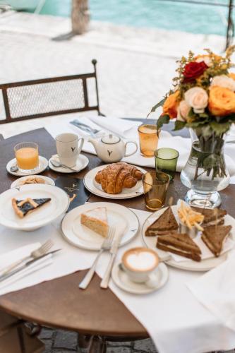 a table with plates of food and a vase of flowers at Pavillon Apartments in Peschiera del Garda