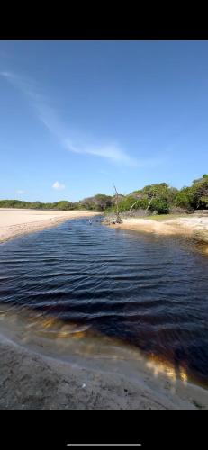 a body of water next to a sandy beach at Lençóis Maranhenses - Casa Armonia in Santo Amaro